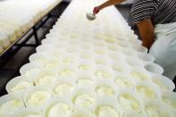 An employee makes camembert cheese at the Fromagerie Durand in the Normandy village of Camembert