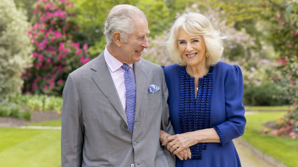 In this handout photo from Buckingham Palace, King Charles III and Queen Camilla stand in the Buckingham Palace gardens on April 10, 2024. - Millie Pilkington/Buckingham Palace/AP