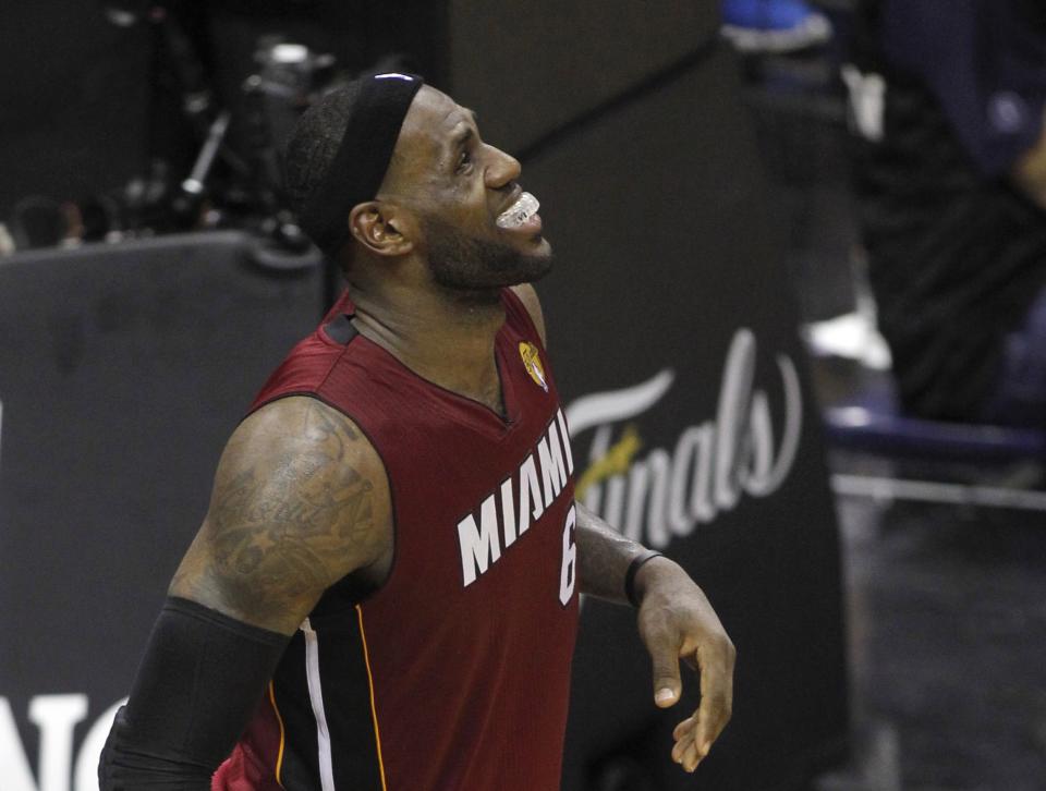 Miami Heat's LeBron James grimaces after hurting his leg during the fourth quarter against the San Antonio Spurs in Game 1 of their NBA Finals basketball series in San Antonio