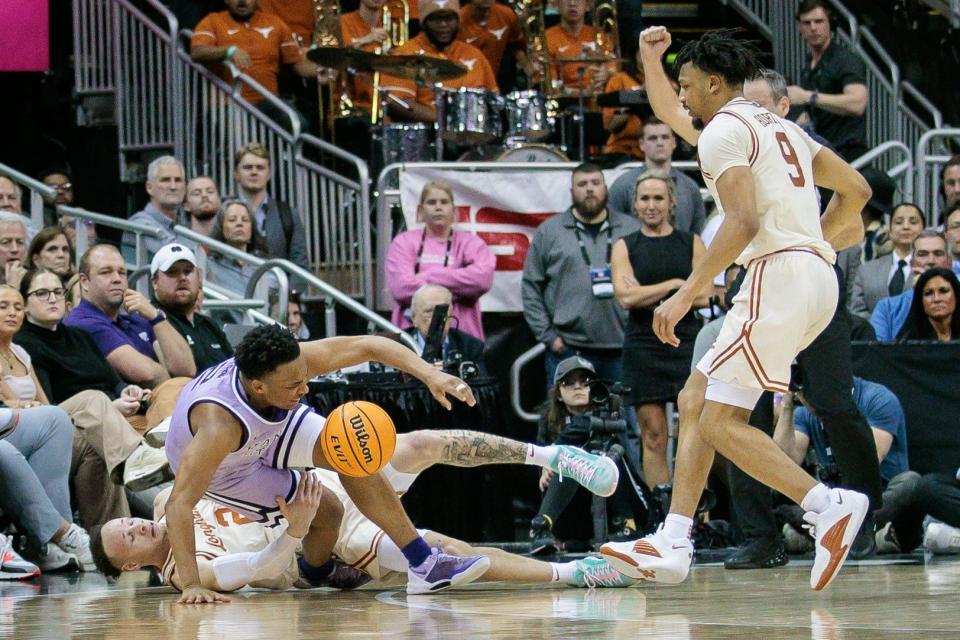 Texas' Chendall Weaver tackles Kansas State's Tylor Perry in the Longhorns' 78-74 loss Wednesday night at the Big 12 Tournament. UT battled foul trouble and shooting woes throughout the second half.
