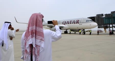 Qatari men take pictures after the Airbus A320-200 aircraft chartered by Qatar Airways landed at Doha's new Hamad International Airport (HIA), April 30, 2014. REUTERS/Fadi Al-Assaad