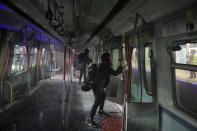 Pro-democracy protesters vandalize a train parked inside the Chinese University MTR station in Hong Kong, Wednesday, Nov. 13, 2019. Protesters in Hong Kong battled police on multiple fronts on Tuesday, from major disruptions during the morning rush hour to a late-night standoff at a prominent university, as the 5-month-old anti-government movement takes an increasingly violent turn. (AP Photo/Kin Cheung)