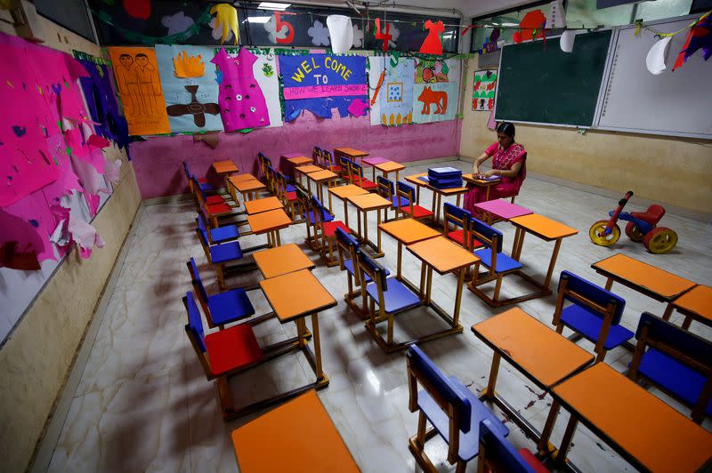 FILE PHOTO: A teacher sits in an empty classroom after Tamil Nadu state government ordered the closure of primary schools across the state amid coronavirus fears, in Chennai