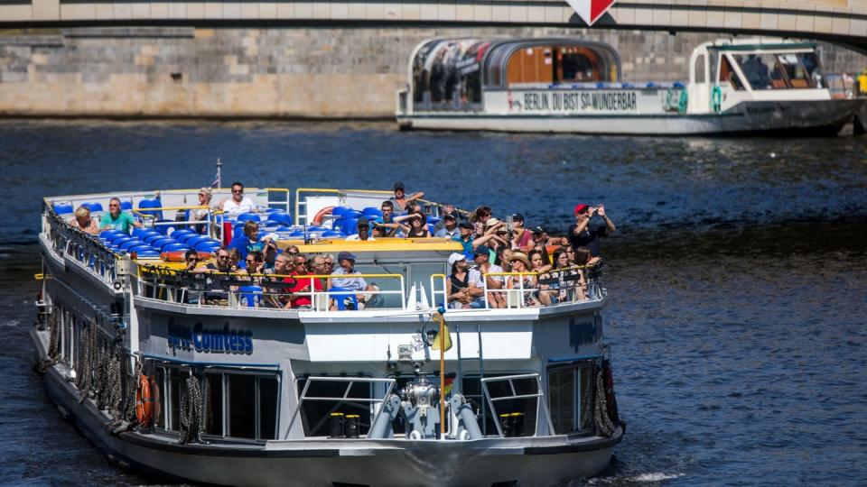 Touristen sind mit einem Ausflugsgsschiff auf der Spree in Berlin unterwegs. Foto: Jens Büttner