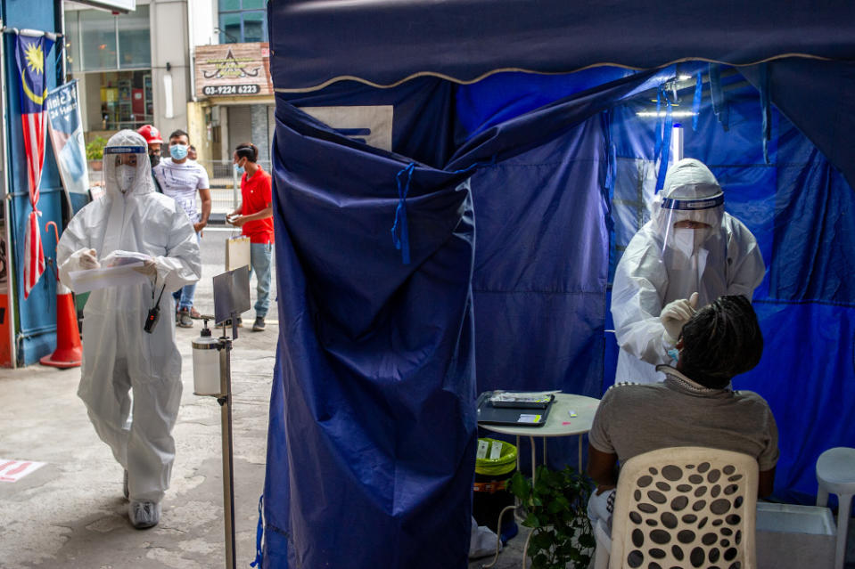 A health worker uses a swab to collect a sample for Covid-19 testing from a man in Jalan Pudu, Kuala Lumpur, January 18, 2021. — Picture by Shafwan Zaidon