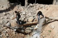 Men inspect a hole in the ground filled with water in a damaged site after airstrikes on the rebel held Tariq al-Bab neighbourhood of Aleppo, Syria September 24, 2016. REUTERS/Abdalrhman Ismail