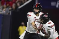 FILE - In this Saturday, Sept. 4, 2021, file photo, Texas Tech quarterback Tyler Shough (12) hands off the ball to running back Tahj Brooks (28) against Houston during the second half of an NCAA college football game in Houston. There are a few simple explanations about why Texas Tech hasn't really spread the ball around that much on offense. Ezukanma makes things look so easy with all those big plays while leading the nation in receiving and Tahj Brooks has more than 100 yards rushing in both games with four touchdowns when he wasn't even expected to be the team's top running back. Plus, the Red Raiders (2-0) just haven't run a whole lot of plays. (AP Photo/Justin Rex, File)