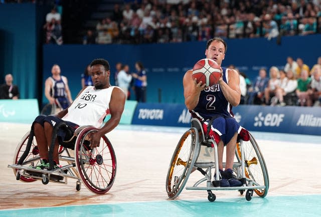 Jake Williams with the ball for the United States as Great Britain's Abdi Jama attempts to give chase