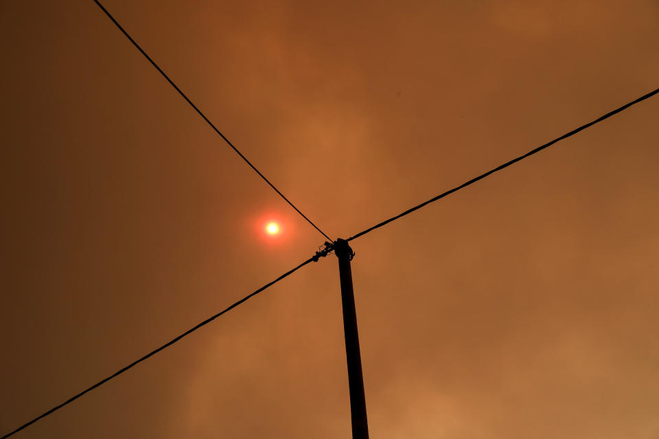 The sun is seen through smoke from a forest fire at Psachna village on the island of Evia, northeast of Athens, Tuesday, Aug. 13, 2019. Dozens of firefighters backed by water-dropping aircraft are battling a wildfire on an island north of Athens that has left the Greek capital blanketed in smoke. (AP Photo/Yorgos Karahalis)