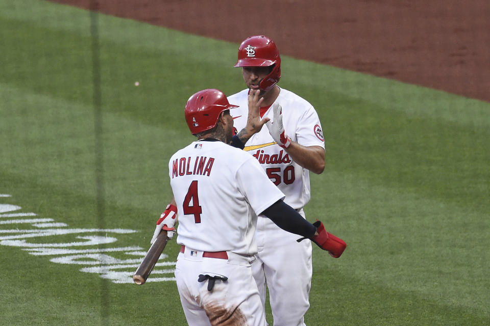 St. Louis Cardinals catcher Yadier Molina, left, is congratulated by teammates St. Louis Cardinals' Adam Wainwright after scoring a run against the Miami Marlins during the second inning of a baseball game Monday, June 14, 2021, in St. Louis. (AP Photo/Joe Puetz)