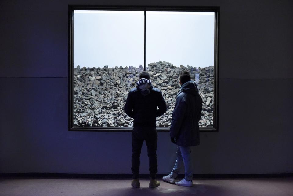 Visitors look at a display of discarded shoes former German Nazi concentration and extermination camp Auschwitz in Oswiecim