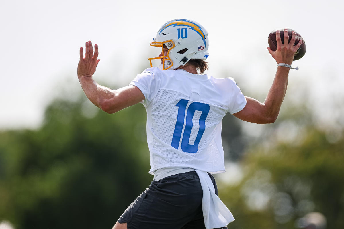 I need a fantasy football team logo of this picture of Justin Herbert. I  want him to be holding a pint of rainbow sherbet ice cream instead of the  football in a