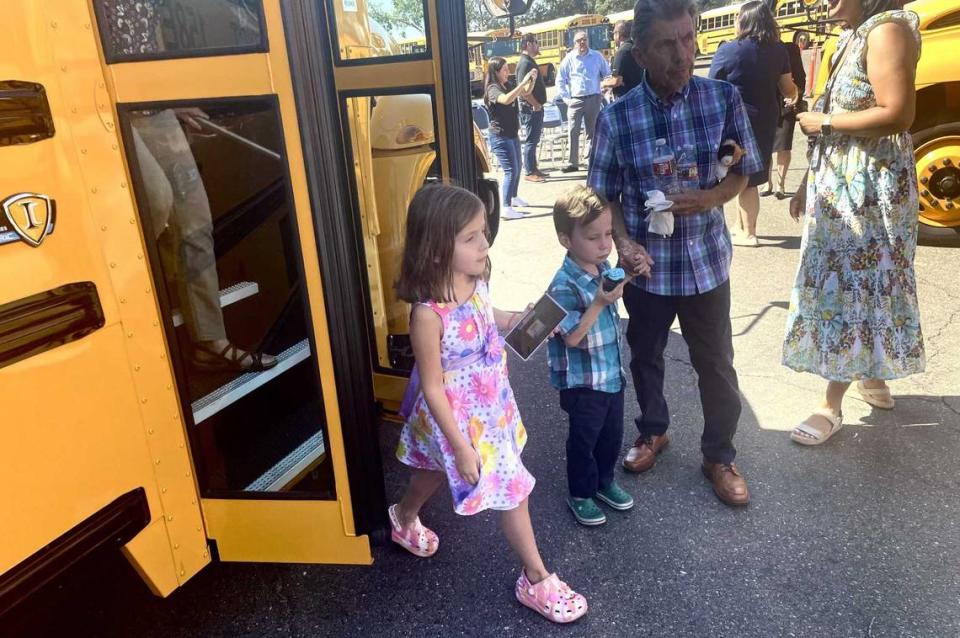 Two school children hop off one of San Juan Unified School District’s new electric buses on July 25, 2024.