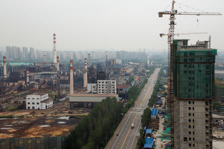 A general view shows the decommissioned Guofeng Iron and Steel plant and an apartment building under construction in Tangshan, Hebei province, China, August 22, 2018. REUTERS/Thomas Peter