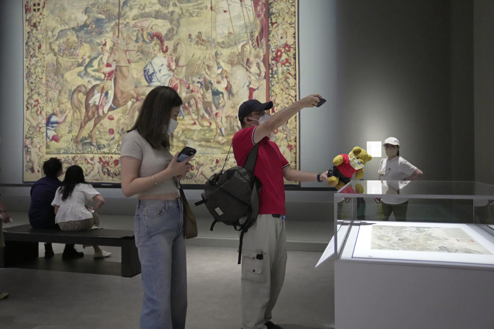 A visitor takes a picture of his teddy bear at the Hong Kong Palace Museum during the first day open to public in Hong Kong, Sunday, July 3, 2022. The museum showcases more than 900 Chinese artefacts, loaned from the long-established Palace Museum in Beijing, home to works of art representing thousands of years of Chinese history and culture.(AP Photo/Kin Cheung)