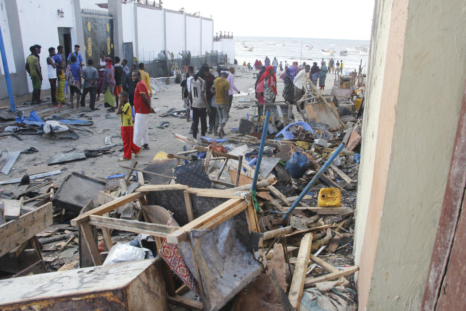 People look at destroyed shops in Mogadishu's Lido beach, Somalia, Saturday, April, 23, 2022, after a bomb blast by Somalia’s Islamic extremist rebels hit a popular seaside restaurant killing at least six people. Ambulance service officials say the explosion occurred Friday evening when many patrons gathered for an Iftar meal to break the Ramadan fast. (AP Photo/Farah Abdi Warsameh)