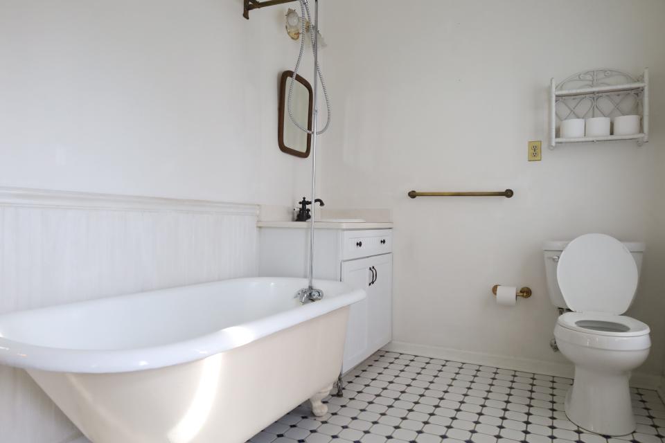 The upstairs bathroom in the Central Gardens home, featuring fresh floor tile and appliances.