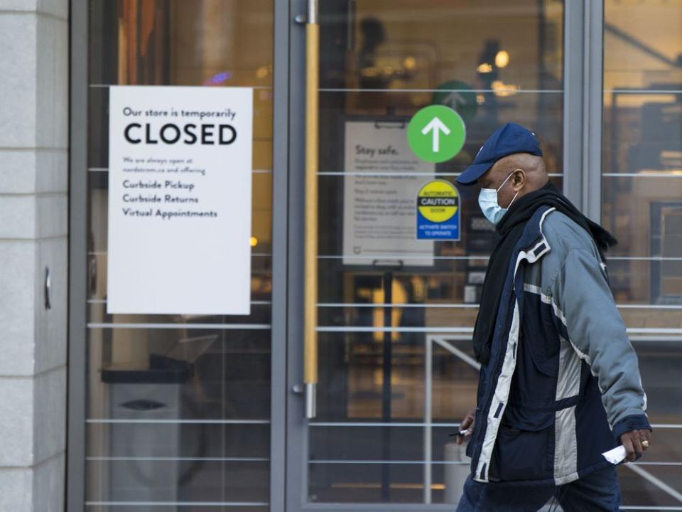  A man walks past a closed clothing store in Toronto.