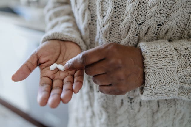 <p>Grace Cary / Getty Images</p> Black female holding pills in the palm of her hand