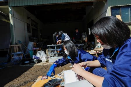 Student volunteers clean debris from an elder's home in the aftermath of Typhoon Hagibis in Yanagawamachi district, Date City