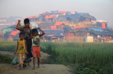 Rohingya refugee children carry supplies through Balukhali refugee camp near Cox's Bazar, Bangladesh, October 23, 2017. REUTERS/Hannah McKay