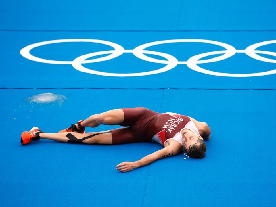 Bence Bicsak of Team Hungary lays on the ground after finishing the Olympic triathlon.