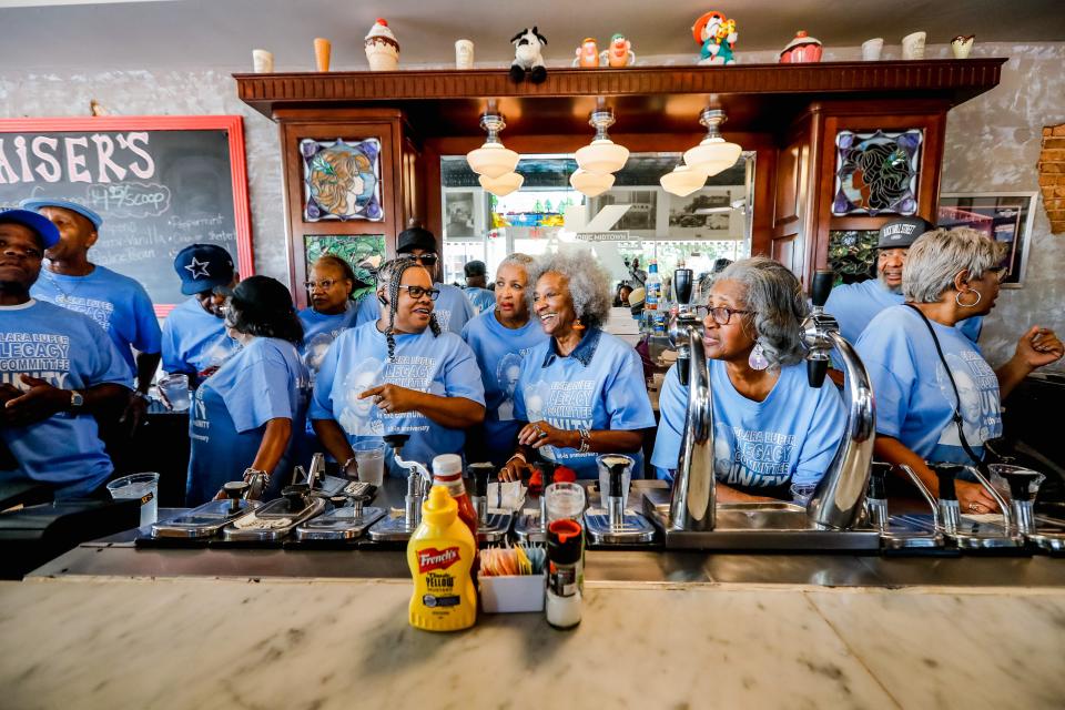 Members of the original 1958 sit-in join a group in a reenactment Saturday at Kaiser's Grateful Bean.