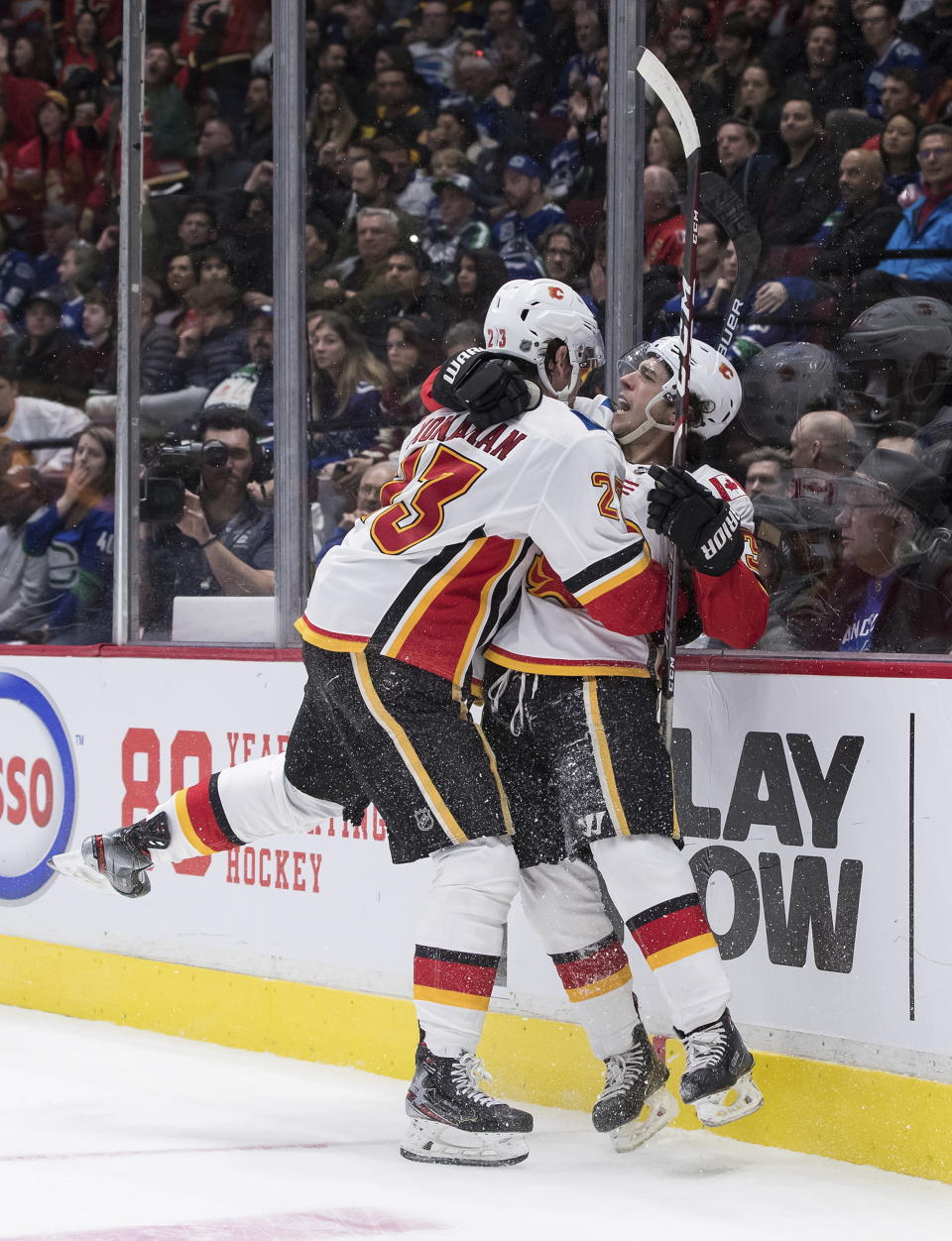 Calgary Flames' Johnny Gaudreau, right, and Sean Monahan celebrate Monahan's goal against the Vancouver Canucks during the third period of an NHL hockey game Saturday, Feb. 8, 2020, in Vancouver, British Columbia. (Darryl Dyck/The Canadian Press via AP)