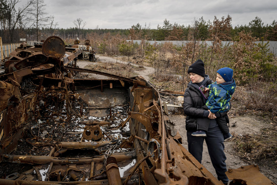 A family in Bucha, Ukraine, examines the remains of a Russian tank destroyed at the beginning of the war, on Feb. 22, 2023. / Credit: Ignacio Marin Fernandez/Anadolu Agency via Getty Images