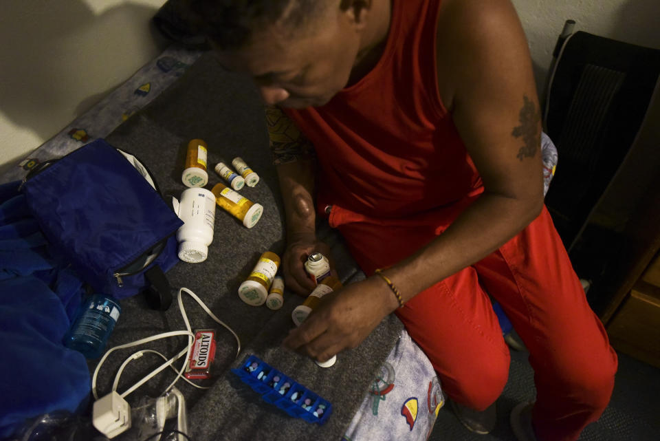 In this early morning Sept. 8, 2018 photo, dialysis patient Elias Salgado packs his medicines in his home as he prepares for his flight, in Vieques, Puerto Rico. Salgado, a 56-year-old renal patient who is diabetic, has high blood pressure and would like to move to the mainland but cannot afford to do so. "It's exhausting," Salgado said about the thrice-weekly trips to the the Puerto Rican mainland to receive treatment. (AP Photo/Carlos Giusti)