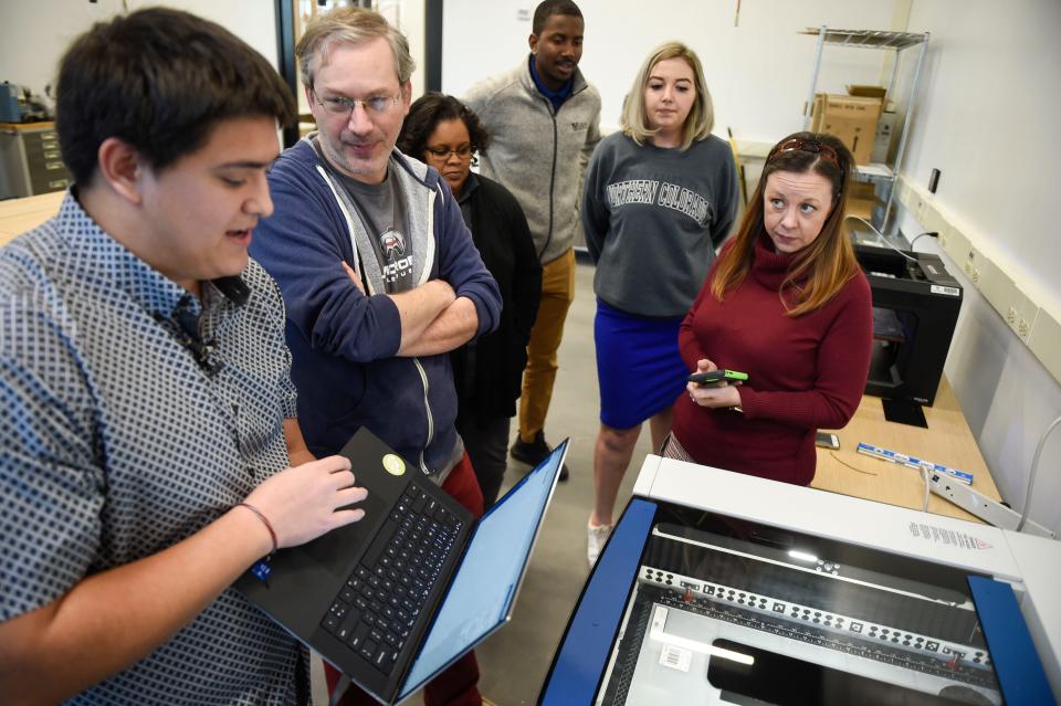 Creative Technologist Luke Steel (left) leads a demonstration on laser cutting in The Garage at the Georgia Cyber Center on Wednesday. Workshop participants designed their own coaster, which was cut out using lasers.