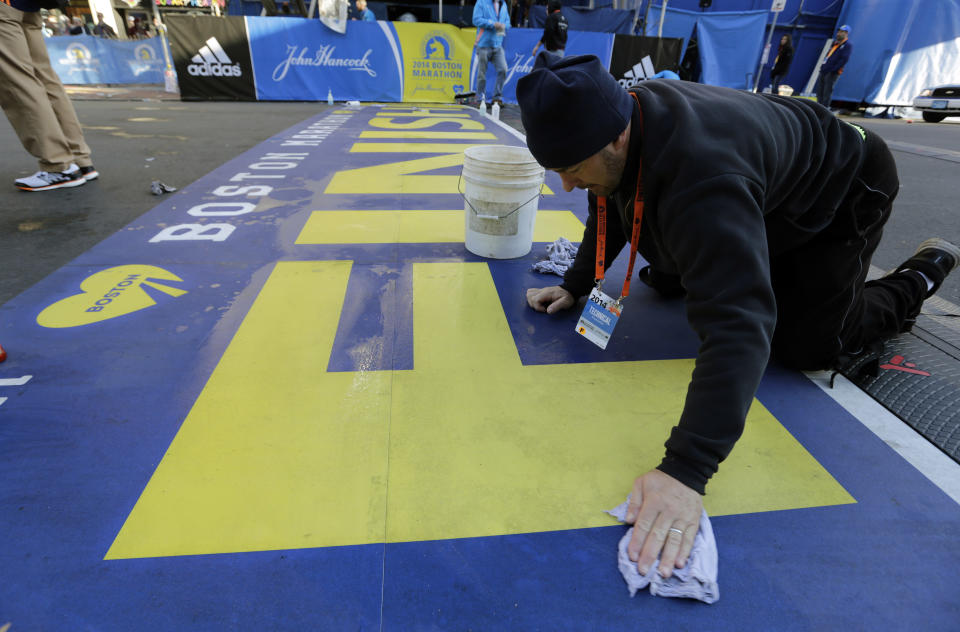 Anthony Bisenti limpia la línea de meta para el 118vo Maratón de Boston, el lunes 21 de abril de 2014, el primero tras el atentado de hace un año, en Boston. (Foto AP/Robert F. Bukaty)