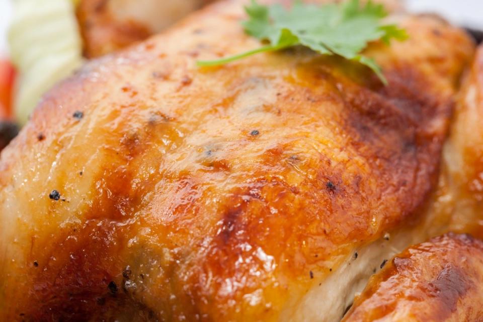 Delicious roasted whole chicken with parsley leaf on top.