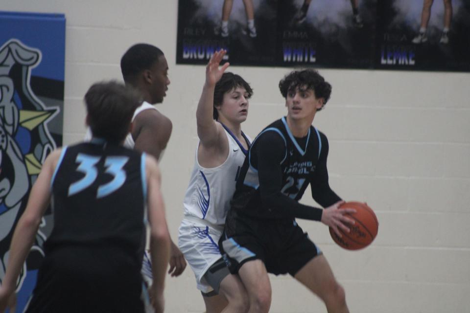 Lansing Catholic senior Jack Jacobs looks to pass the ball while Ionia sophomore guard Spencer Tooker defends during a boys varsity basketball game Friday, Jan. 27, at Ionia High School. Ionia won the game, 57-43.