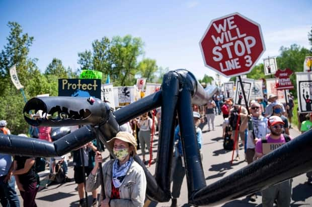 Demonstrators in Minnesota protest against the Line 3 pipeline replacement project in June 2021. Enbridge confirms two employees of one of its contractors have been fired after they were arrested in a sex trafficking sting. (Alex Kormann/Star Tribune via AP - image credit)