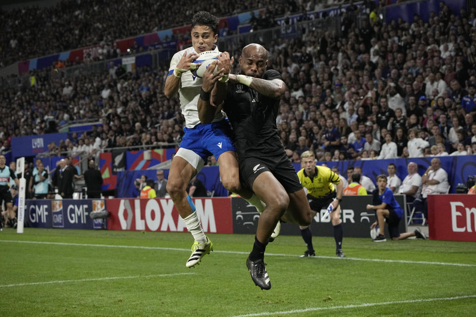 New Zealand's Mark Telea, right, and Italy's Ange Capuozzo fight for the ball during the Rugby World Cup Pool A match between New Zealand and Italy at the OL Stadium in Lyon, France, Friday, Sept. 29, 2023. (AP Photo/Laurent Cipriani)