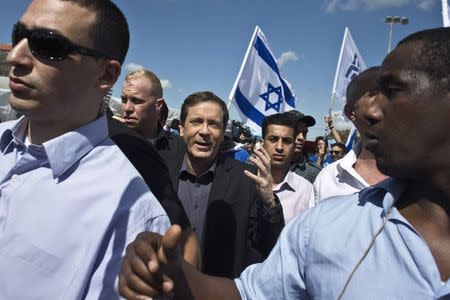 Isaac Herzog (C) is escorted by bodyguards during a campaign stop at a fruit and vegetable market in Lod near Tel Aviv March 3, 2015. REUTERS/Nir Elias