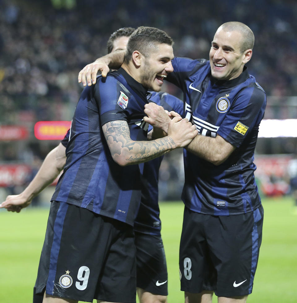 Inter Milan forward Mauro Icardi, left, of Argentina, celebrates with his compatriot teammate Rodrigo Palacio after scoring during the Serie A soccer match between Inter Milan and Bologna at the San Siro stadium in Milan, Italy, Saturday, April 5, 2014. (AP Photo/Antonio Calanni)