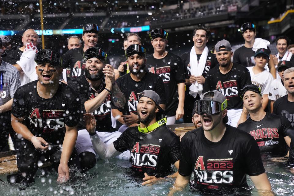 The Arizona Diamondbacks players leap into the outfield pool to celebrate their 4-2 series-clinching win against the Los Angeles Dodgers during their National League Division Series game at Chase Field in Phoenix on Oct. 11, 2023.