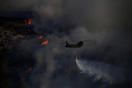 A Chinook helicopter makes a water drop as a wildfire burns in the area of Kalyvia, near Athens, Greece July 31, 2017. REUTERS/Alkis Konstantinidis