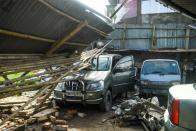 A man checks cars in a garage damaged by cyclone Amphan in Satkhira on May 21, 2020. (Photo by MUNIR UZ ZAMAN/AFP via Getty Images)