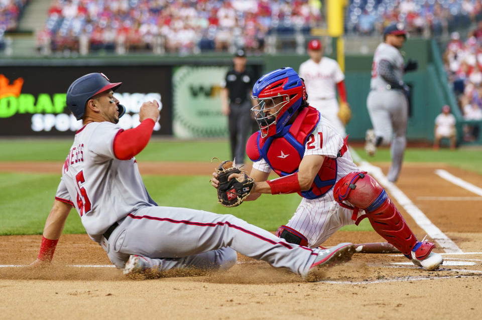 Philadelphia Phillies catcher Garrett Stubbs tags out Washington Nationals' Joey Meneses on a grounder by Luke Voit, right rear, during the first inning of a baseball game Saturday, Sept. 10, 2022, in Philadelphia. (AP Photo/Chris Szagola)