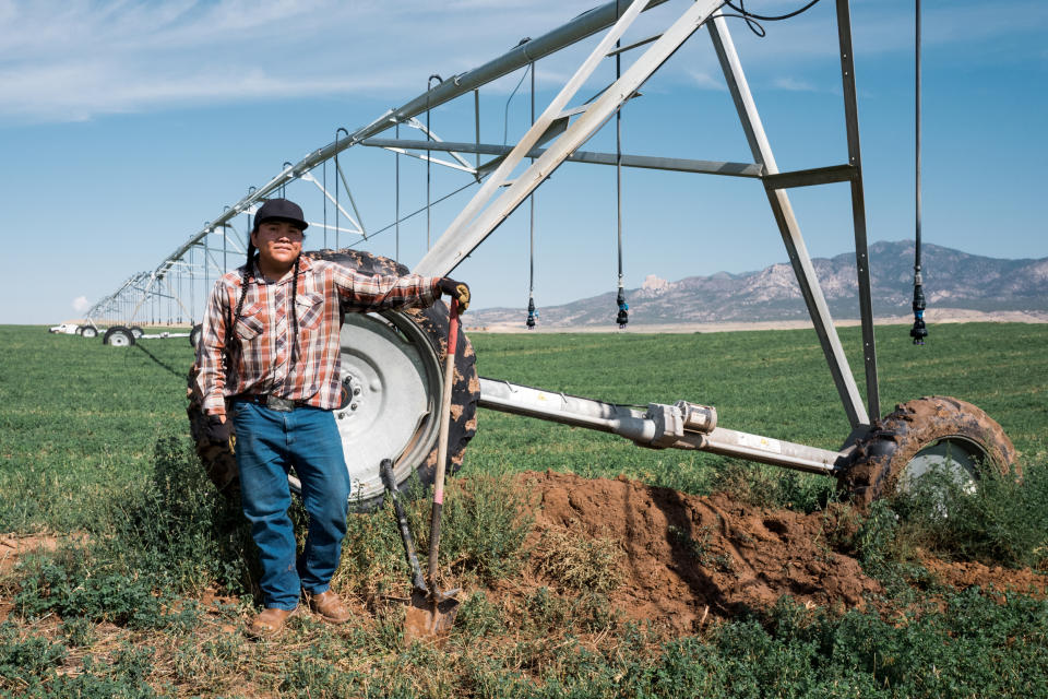 Kolton Begay, a worker at Ute Mountain Ute Tribe Farm and Ranch Enterprise,  in front of a pivot irrigator on Sept. 8, 2022. He works alone as about half of the farm's workers have been laid off in recent years due to Covid and the drought. (Cate Dingley for NBC News)