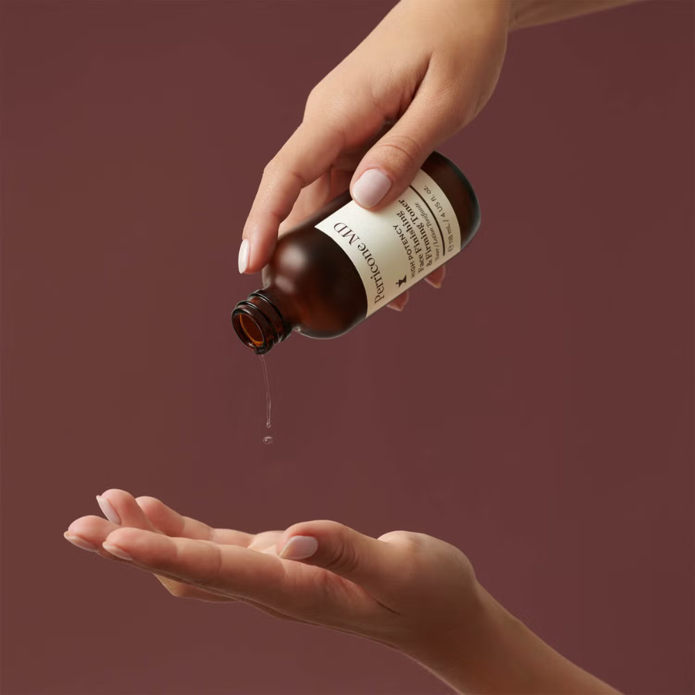  Perricone MD bottle pouring liquid onto hand, with brown background. 