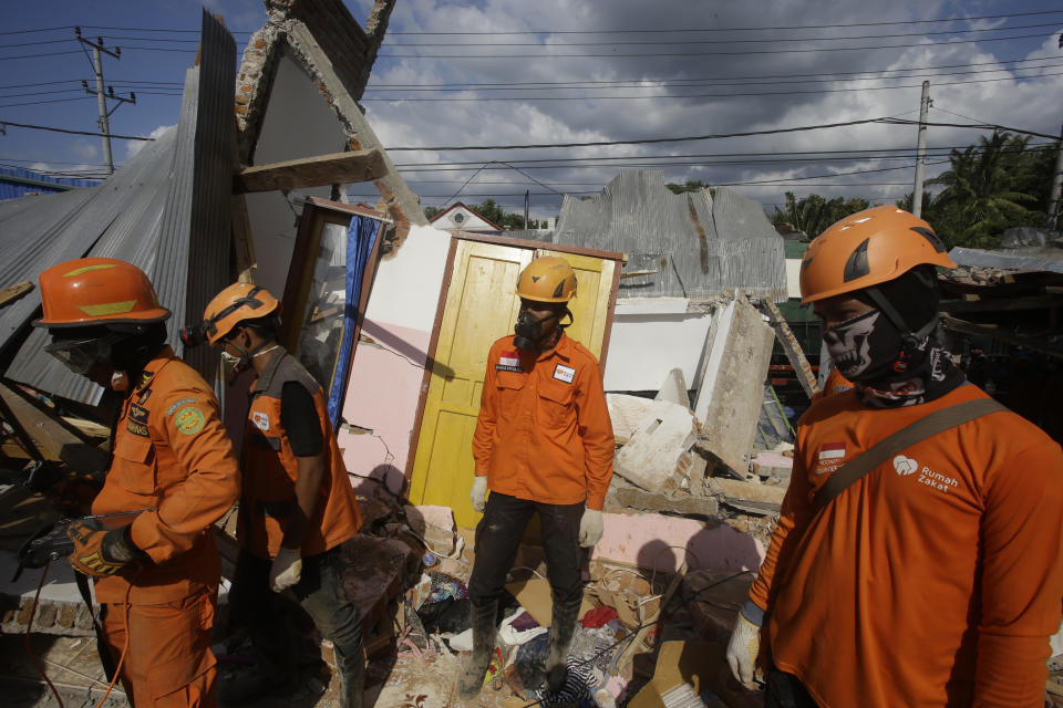 Emergency teams continue to search for victims in an earthquake-damaged house in Tanjung, Lombok, Indonesia, Tuesday, Aug. 7, 2018. Thousand left homeless by a powerful quake that ruptured roads and flattened buildings on the Indonesia tourist island Lombok as authorities said rescuers hadn't yet reached all devastated areas and expect the death toll to climb. (AP Photo/Firdia Lisnawati)