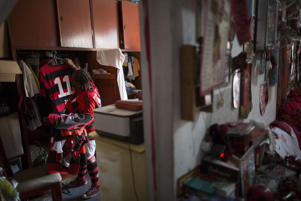 In this April 28, 2014 photo, Maria Boreth de Souza, alias Zica, organizes her Flamengo soccer jerseys in her closet at home in the Olaria neighborhood of Rio de Janeiro, Brazil. Flamengo is equally fanatical about Brazil's national team and "I pray they win the World Cup," which starts June 12. "If Brazil loses the tournament the statue of Christ the Redeemer will pack his bag and leave the city for good," she said. (AP Photo/Leo Correa)