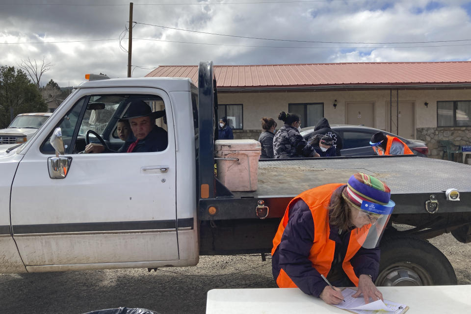 Motorists including Elmer Serna, in driver's seat, awaited vaccine shots as medical workers complete paperwork at a drive-thru immunization clinic at a motor inn in Mora, N.M., on Tuesday, April 20, 2021. New Mexico is among the states with the highest rates of vaccination for COVID-19 and efforts are underway to respond to skepticism and misinformation about the effectiveness and risks of immunization. First Lady Jill Biden was kicking off a visit to the U.S. Southwest with a tour of a vaccination clinic in Albuquerque. (AP Photo/Morgan Lee)