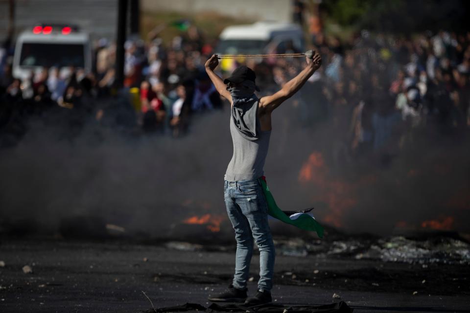 Palestinians clash with Israeli forces at the Hawara checkpoint, south of the West Bank city of Nablus, Tuesday, May 18, 2021.