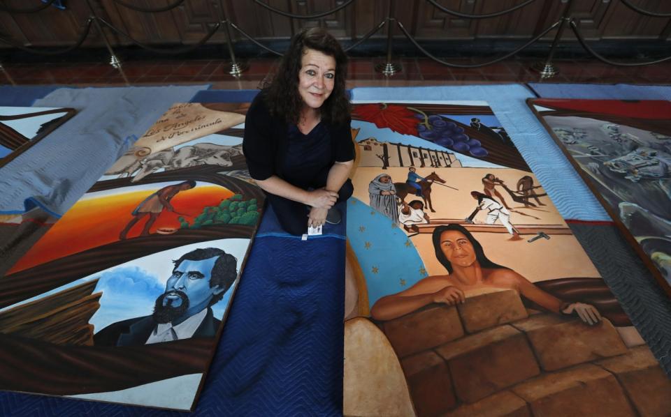 Barbara Carrasco with sections of her mural, "L.A. History: A Mexican Perspective," as it was being installed at Union Station in L.A. in 2017.