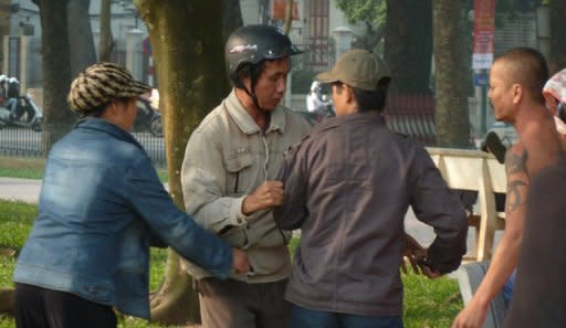 A Vietnamese Falungong follower (2nd L, with helmet) is questioned by plainclothes police during a protest in front of the Chinese embassy in Hanoi in November. The Vietnamese government says it respects freedom of belief and religion. However, Falungong -- which has two to three thousand members in Vietnam -- is not officially recognised in the country